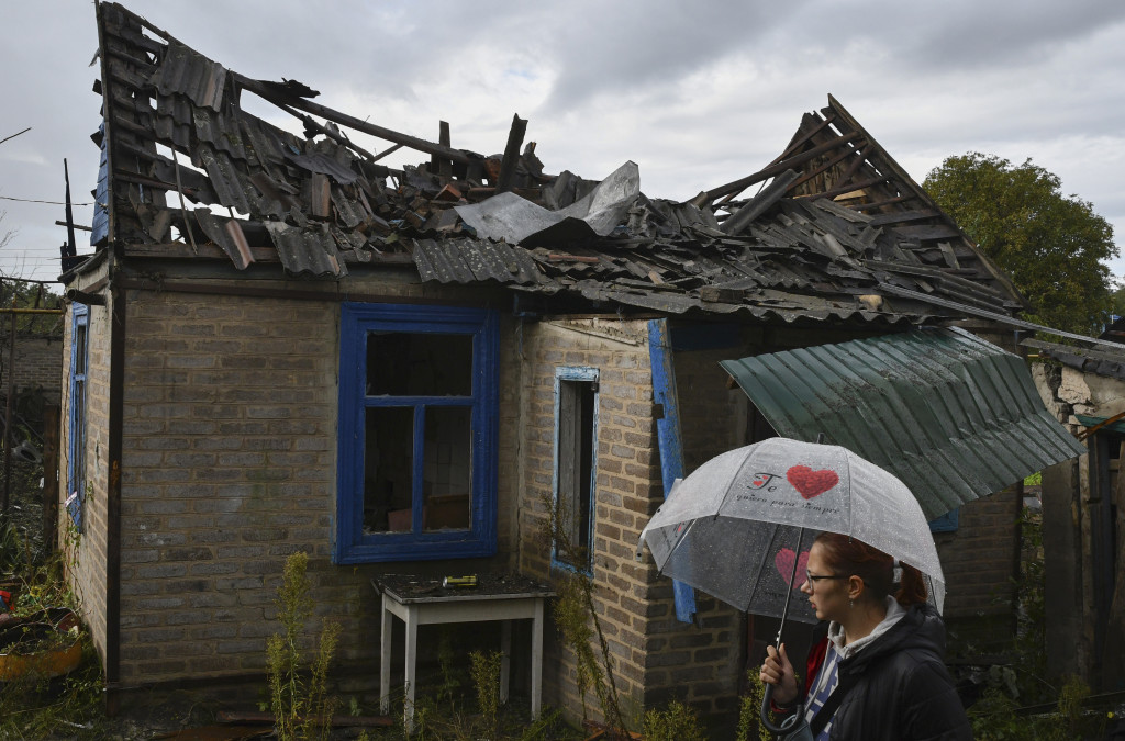 當地居民站在她的被俄軍破壞的住宅樓旁邊。AP
