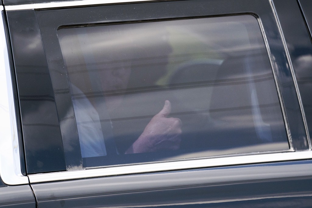 特朗普應訊前現身高爾夫俱樂部，隔車窗向支持者豎大拇指。AP