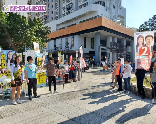 謝潔泳(左方佩戴黃色彩帶者)和林港坤(右方橙色背心者)各據路口一方拉票。