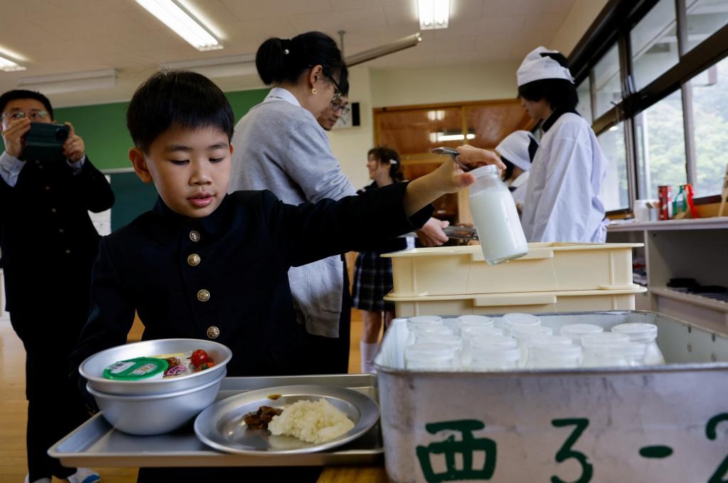 這名來自中國的遊客取學生午餐及牛奶享用。