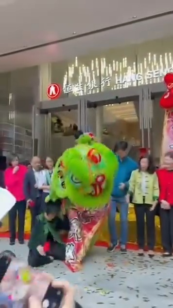 一隻綠色醒獅在準備採青時突然「腳軟」失去平衡,整個獅頭直接砸落前方一名女士的頭頂上 。 一隻綠色醒獅在準備採青時突然「腳軟」失去平衡,整個獅頭直接砸落前方一名女士的頭頂上 。