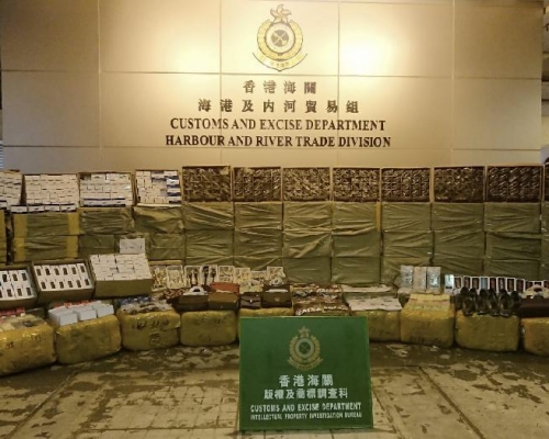 海關人員在屯門內河船碼頭海關驗貨場一個貨櫃內檢獲約400箱懷疑冒牌貨物,包括手提電話及配件、手錶、衣物及手袋等,估計市值約400萬元。 海關提供