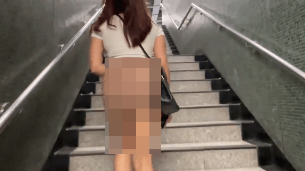 著短裙的女子走上樓梯，拍攝者從後拍攝。