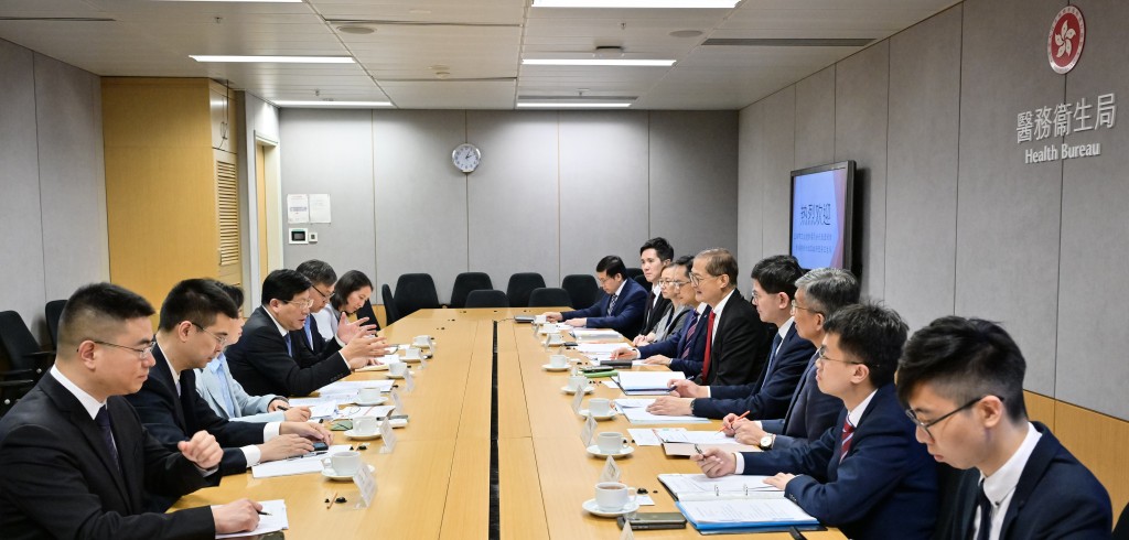 卢宠茂（右五）与上海市衞健委主任闻大翔（左四）率领的代表团举行会议。