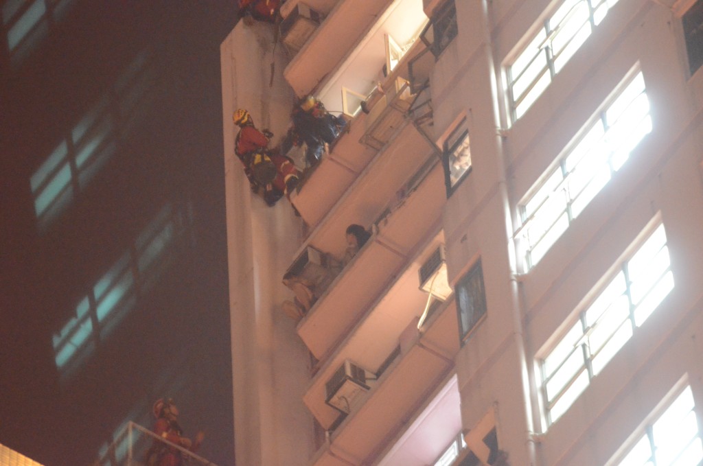 案發日單位內的李威龍及廖子文爬出窗外逃走，最後由消防救回。資料圖片
