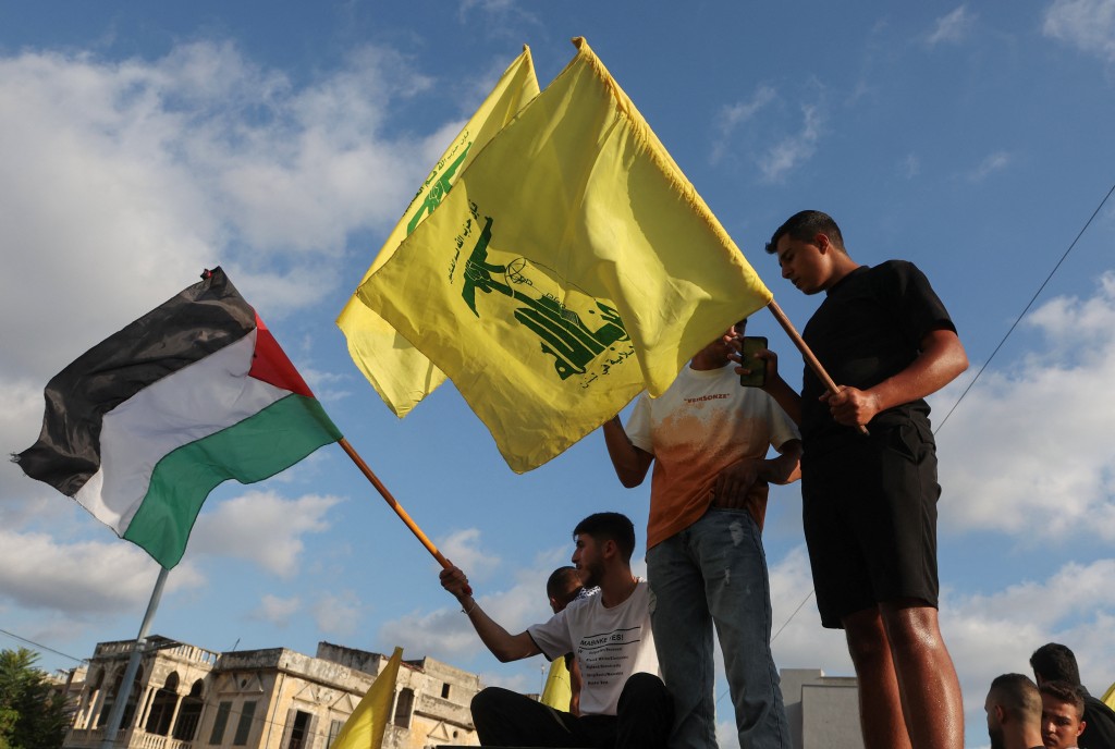 黎巴嫩有人舉起哈馬斯和巴勒斯坦的旗幟。（路透社）