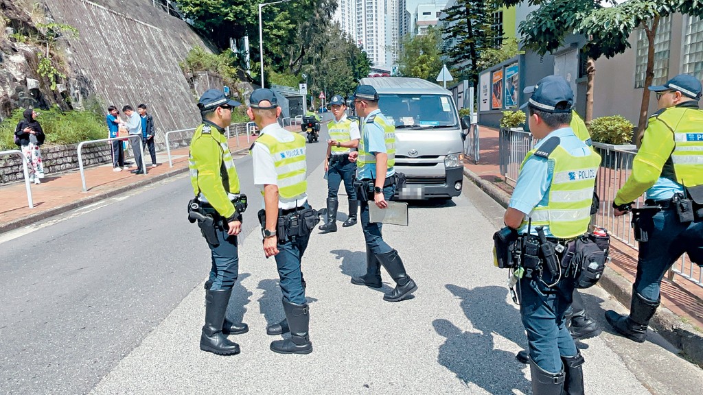 肇事客貨車車頭凹陷,警員在場調查。