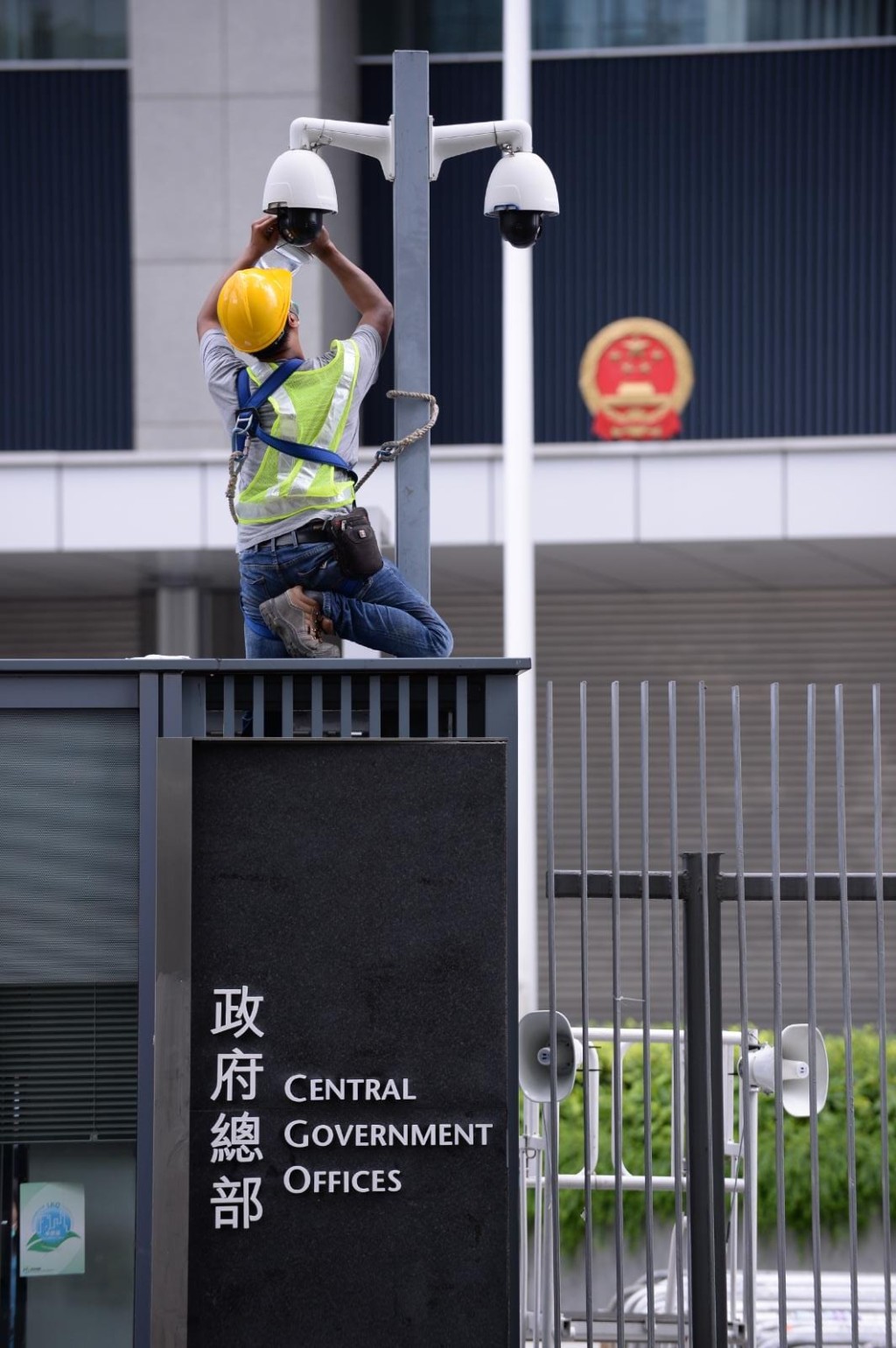 有工人清洗及擦拭政府總部外的閉路電視