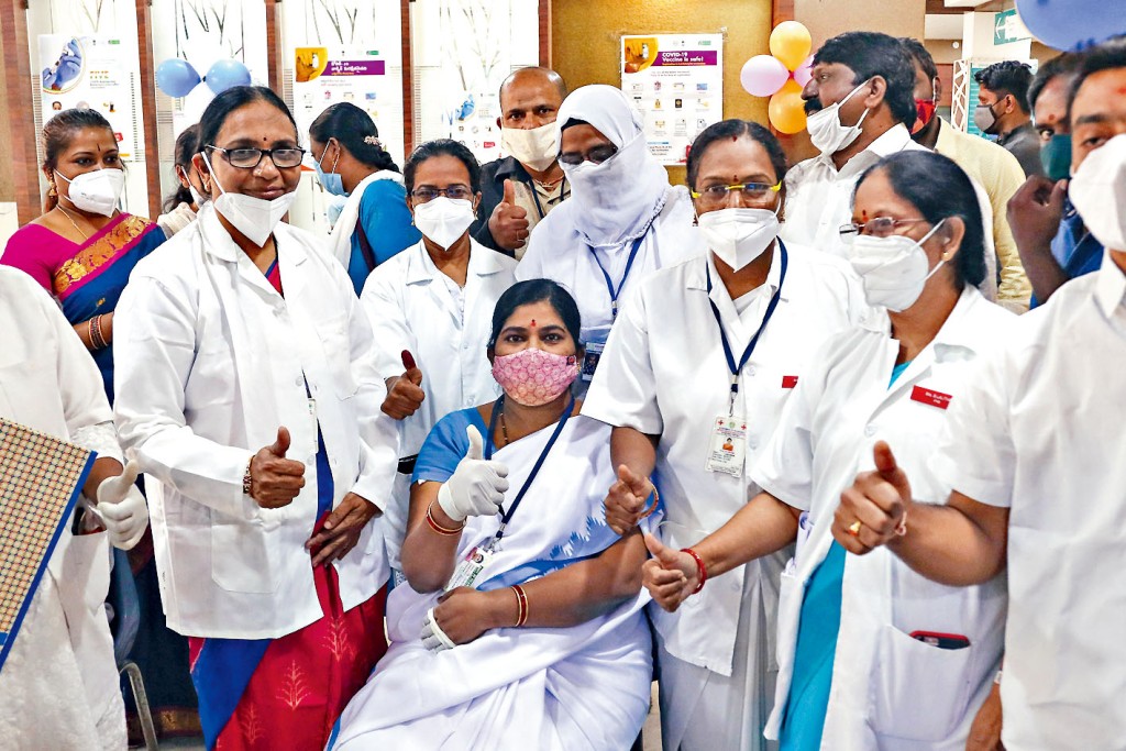 ■在海德拉巴一家政府醫院，醫院職員圍繞一名剛接種疫苗的同事，竪起拇指。