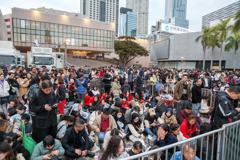 市民及遊客在文化中心對出海傍等候㮒花匯演舉行。