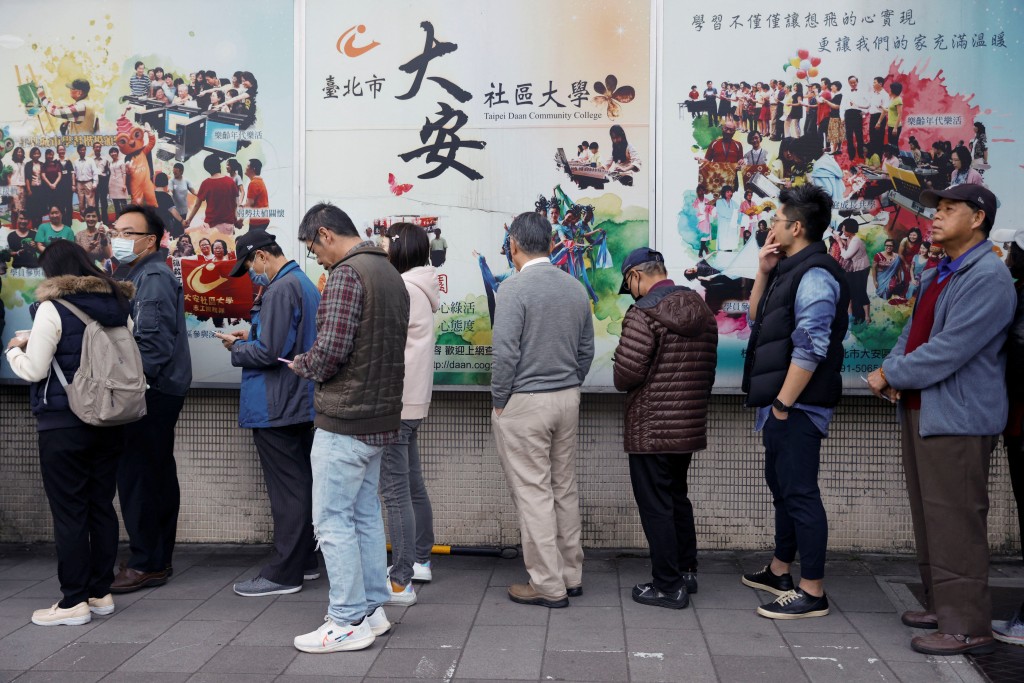 在台北，民众今早等待投票所开放投票。 路透社