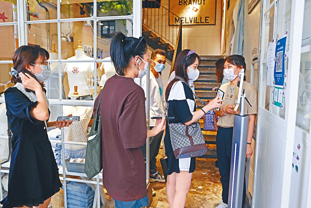 日常生活涉個人數據收集，圖為上海市民進入商鋪前核驗健康碼。