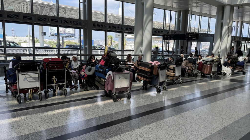 贝鲁特国际机场旅行在行李旁等候。 路透社 