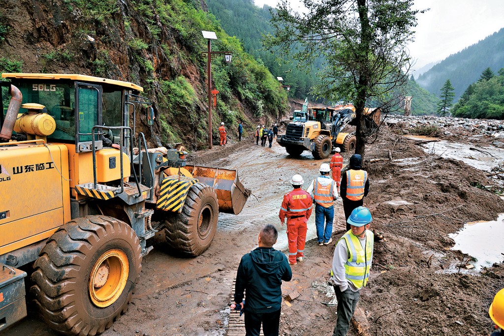 救援人員在山洪災害現場搶修道路。