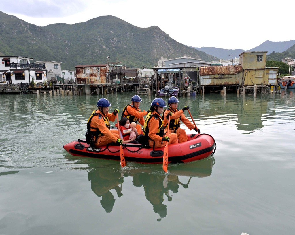 演练模拟民众安全服务队队员以橡皮艇拯救模拟被困的居民。政府新闻处图片