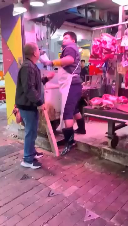 一名身材壮健的鱼档职员出拳挥向男顾客的面部。