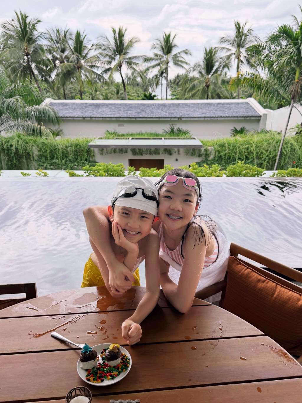 譚俊彥與任祉妍的一對寶貝仔女在泳池邊貼頭合照，甜笑模樣完美遺傳了父母的優良基因。
