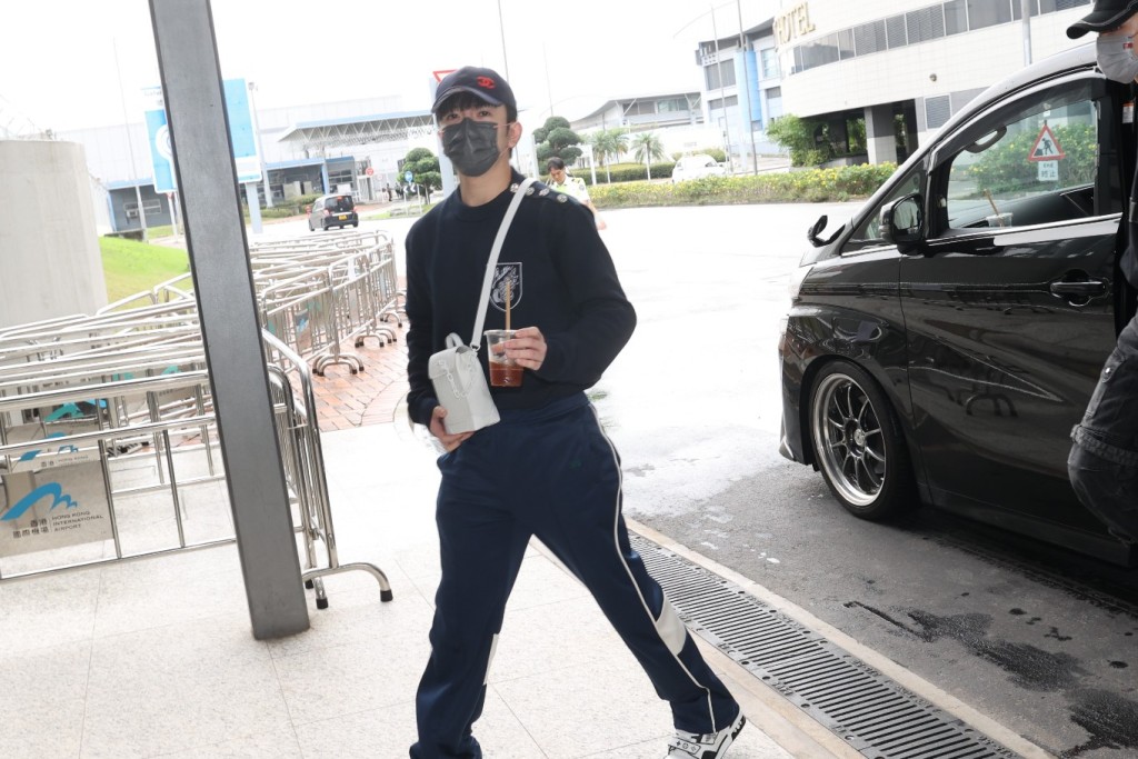 Anson Lo拿着咖啡到機場。