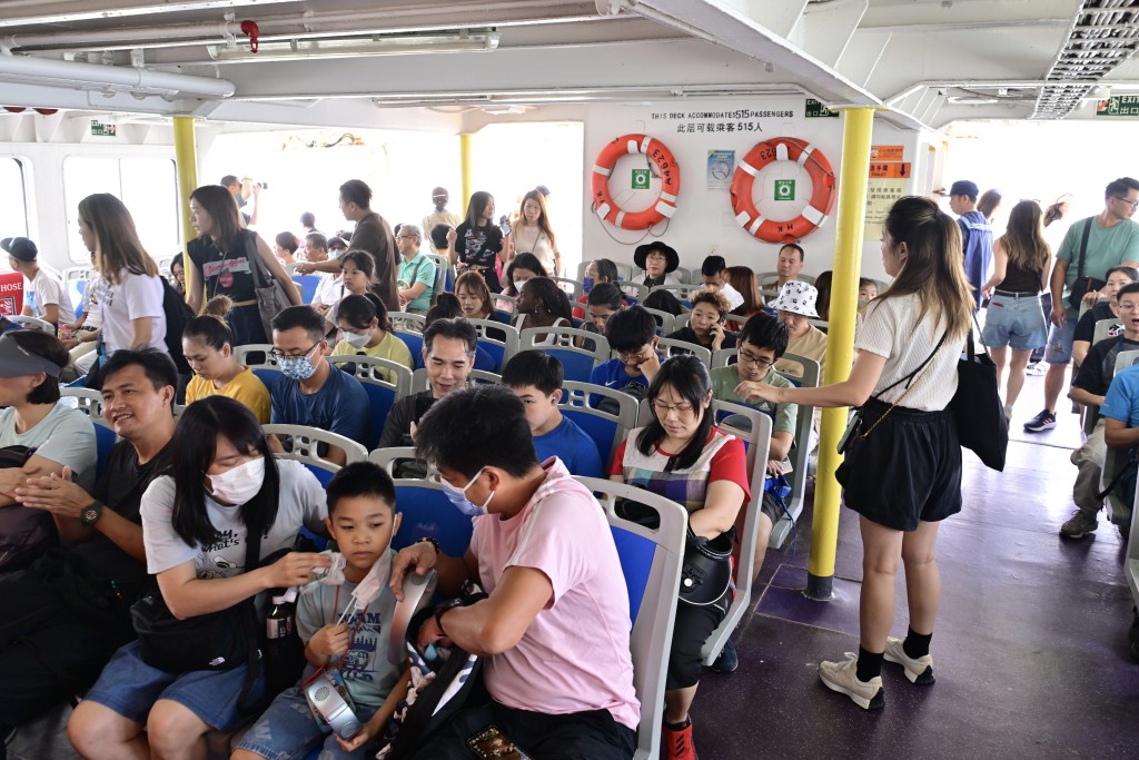 至中午，入长洲人潮继续增加，中环码头大批市民排队搭船，有乘客未能找到座位。（陈极彰摄）