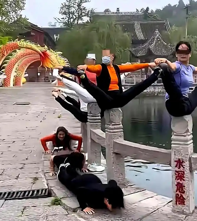 多名大媽將湖邊石欄杆的柱頭當成「瑜伽墊」，大玩高難度「擘髀」動作，地上還有人在爬行。