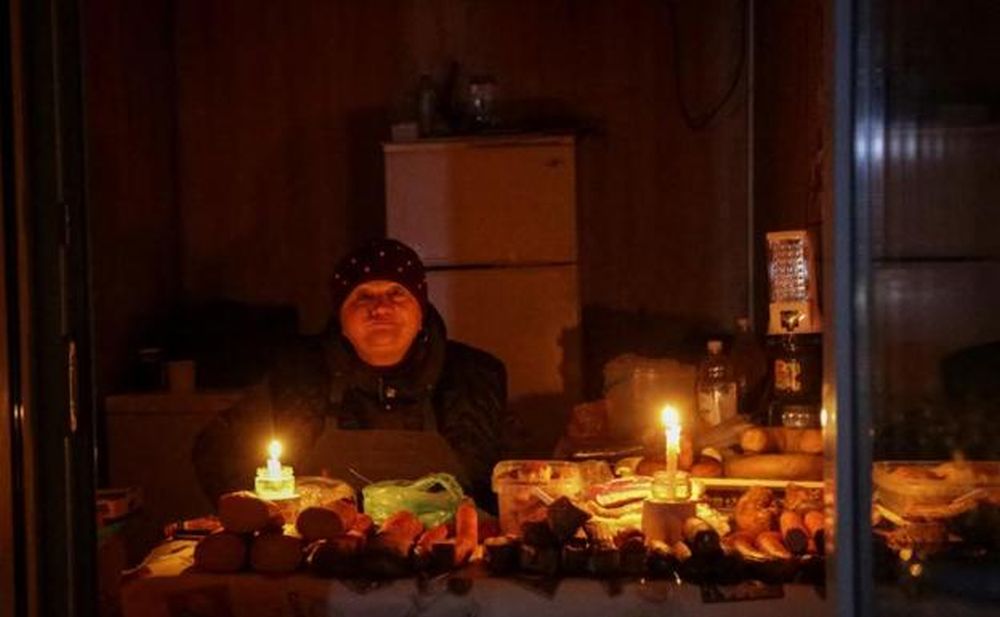 在敖德薩的一條街道上，一個小販用蠟燭照亮了她的攤位。 路透