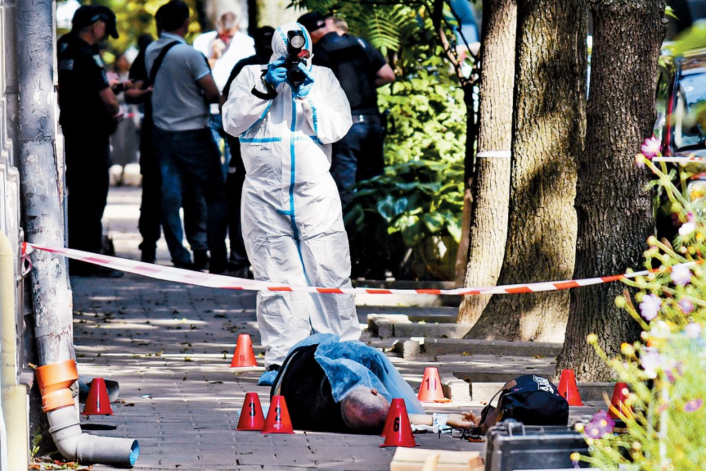 鑑證人員在現場拍攝帕魯比的遺體。