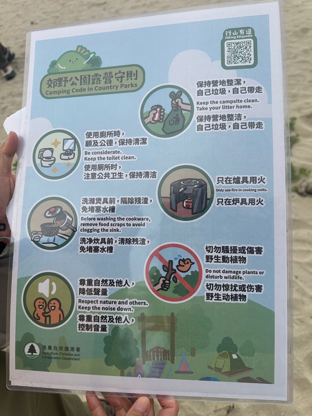 漁護署人員遞出宣傳牌展示文明露營守則。 漁護署人員遞出宣傳牌展示文明露營守則。