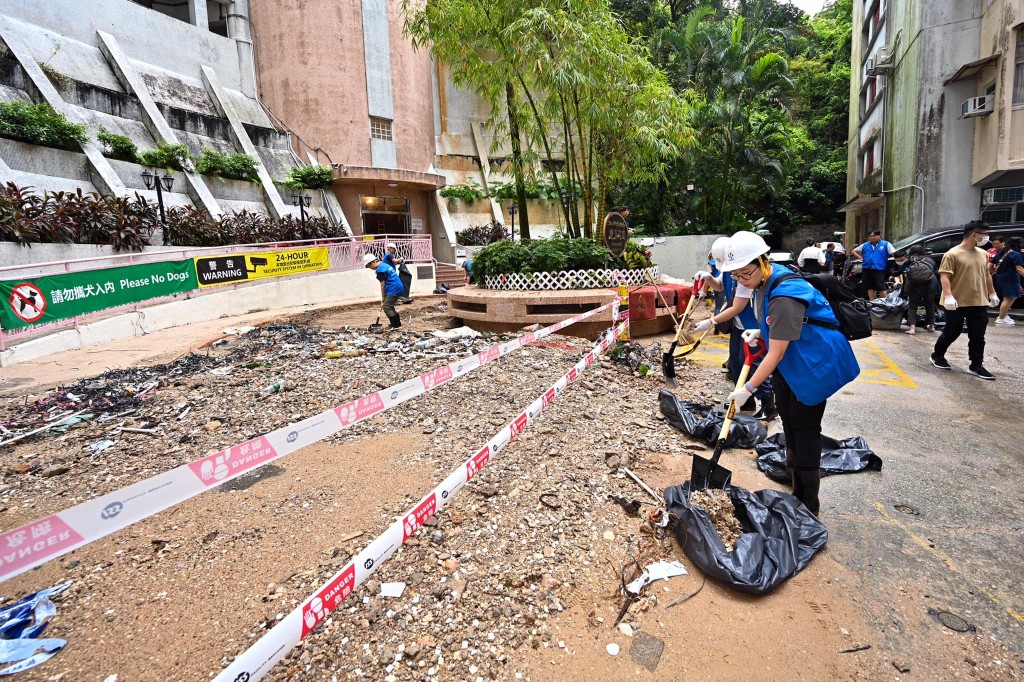 应急队成员在鰂鱼涌街及筲箕湾道清理路面上的垃圾、树枝落叶，亦移走因暴雨而冲到路面的沙泥。公务员事务局fb
