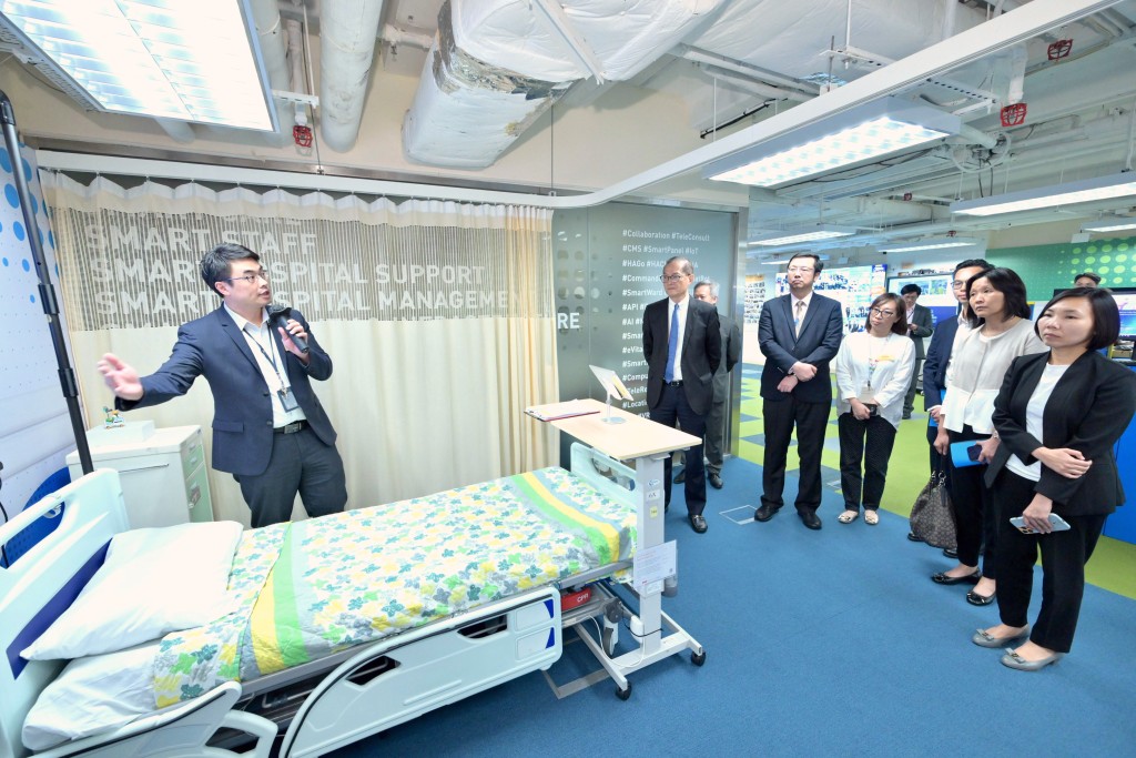 卢宠茂听取医管局人员介绍发展智慧医院的进展。政府新闻处图片