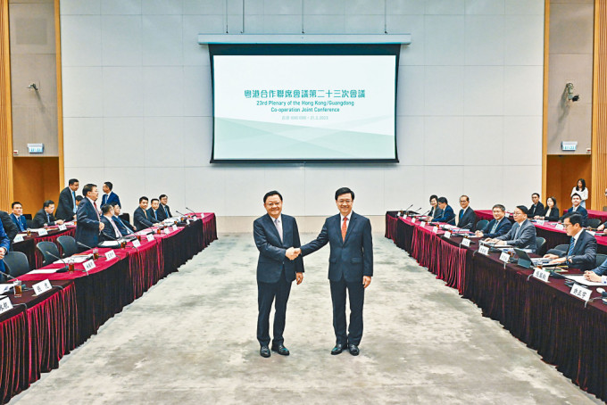 行政长官李家超（右）及广东省省长王伟中在去年会议前握手。资料图片