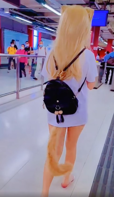 影片開頭見該名頭戴貓耳頭飾、頸帶有皮鍊的長髮女子，經港鐵閘機入站。
