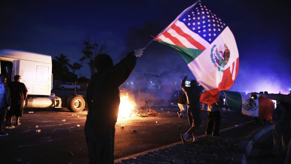 洛杉矶示威|康普顿示威者挥舞美国墨西哥组合旗。 美联社 洛杉矶示威|康普顿示威者挥舞美国墨西哥组合旗。 美联社