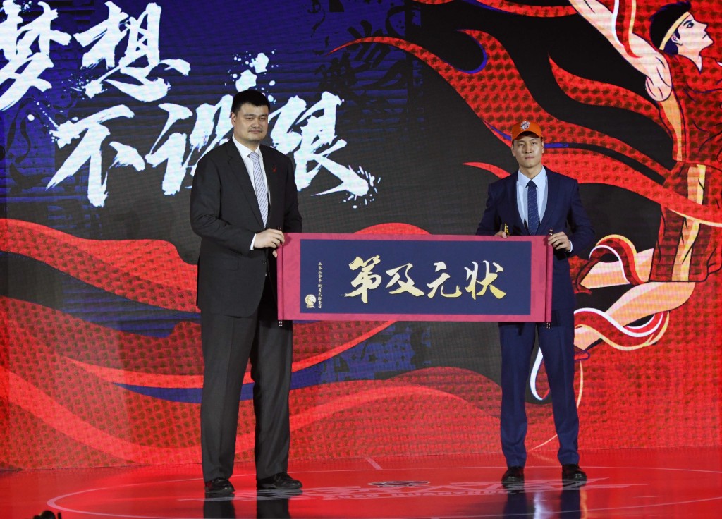 时任CBA公司董事长姚明（左）与2020年选秀状元区俊炫（右）合影。新华社