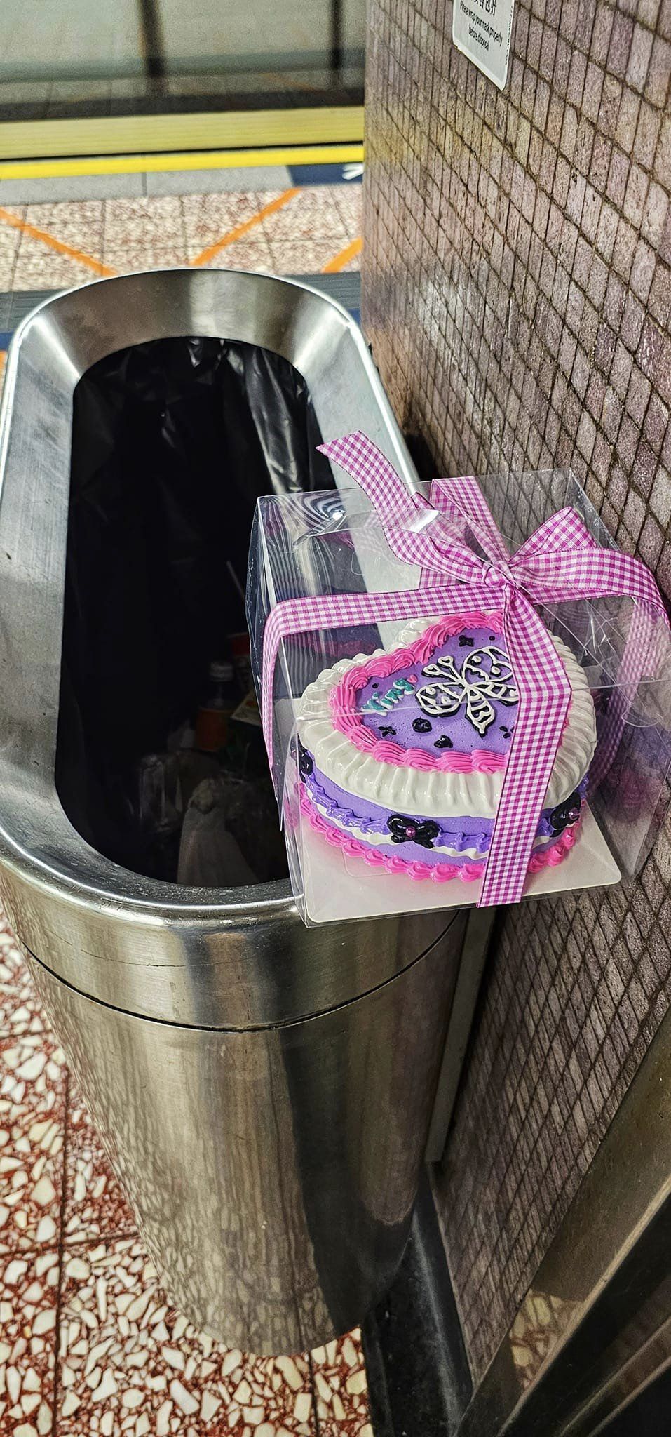 網上流傳一個寫有「Ying」字的紫色蛋糕，被棄於港鐵月台垃圾桶邊緣的相片。網圖
