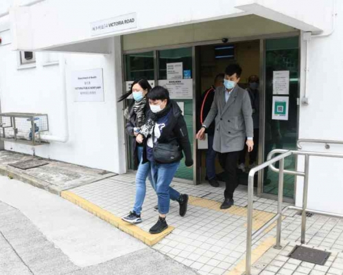 一名女家屬(中間)由警方福利部人員陪同下認屍。楊偉亨攝