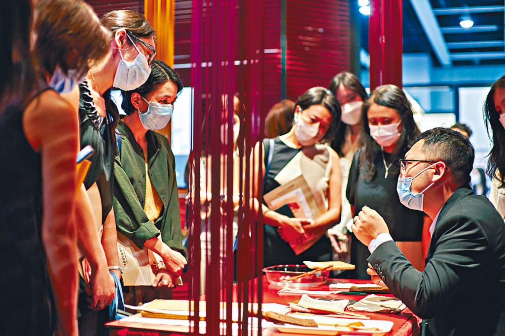 呂智超（右一）於典亞藝博2021向公眾介紹修復書畫的技術和工具。