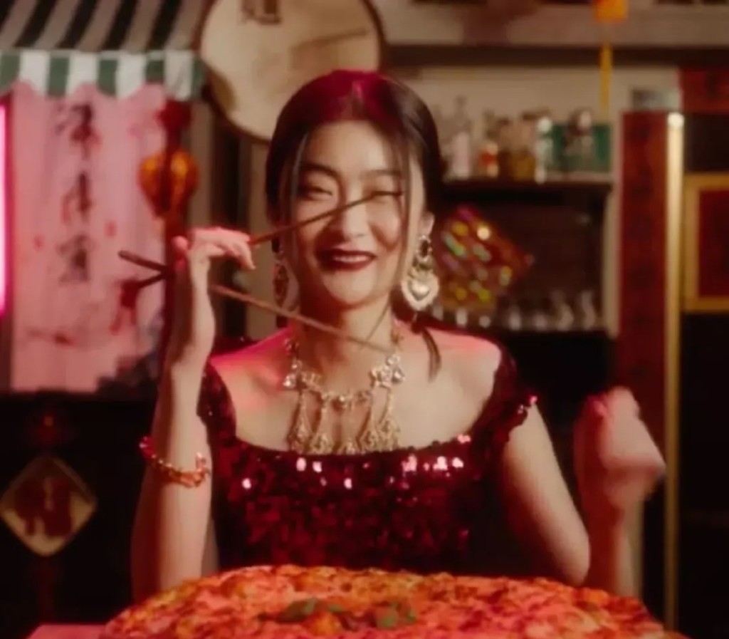 片中拍攝了亞裔模特兒分別用筷子吃意大利傳統Pizza及意粉的情境。 網圖