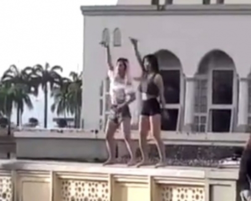 兩名中國女遊客在沙巴的清真寺前圍牆上熱舞，惹來各方猛烈評擊。(網圖)