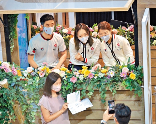 (上排左起)羽毛球混雙鄧俊文、謝影雪及滑浪風帆陳晞文,與市民合照。