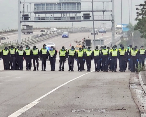 警員一字排開低頭搜索。