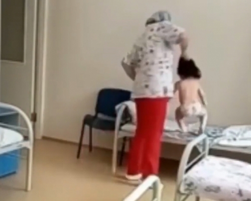 俄羅斯護士被拍下扯女病童頭髮扔上病牀。(網圖)