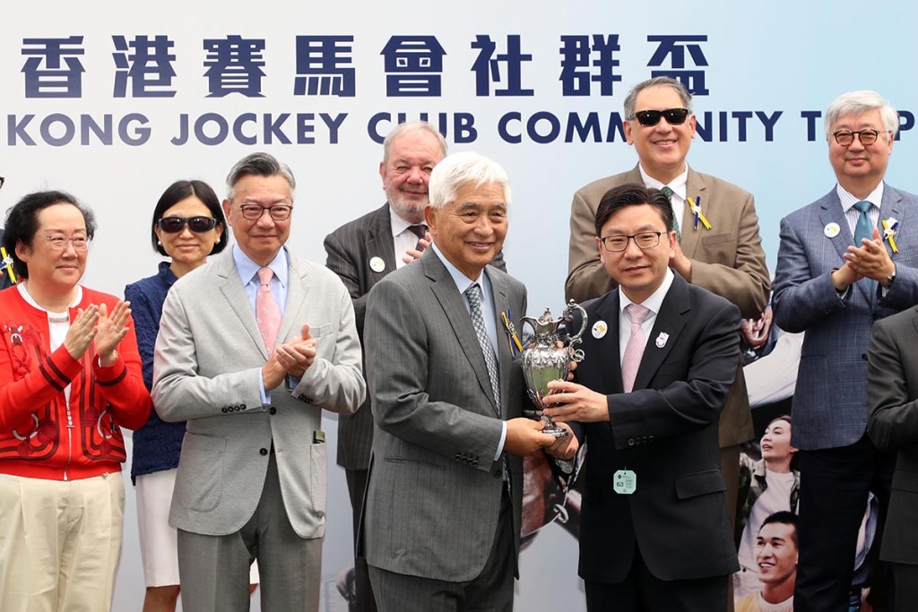 勞褔局局長孫玉菡（前排右）於「香港賽馬會社群盃」賽事後，頒發獎盃予頭馬「金馳」的馬主榮智健（前排左）。（馬會提供）