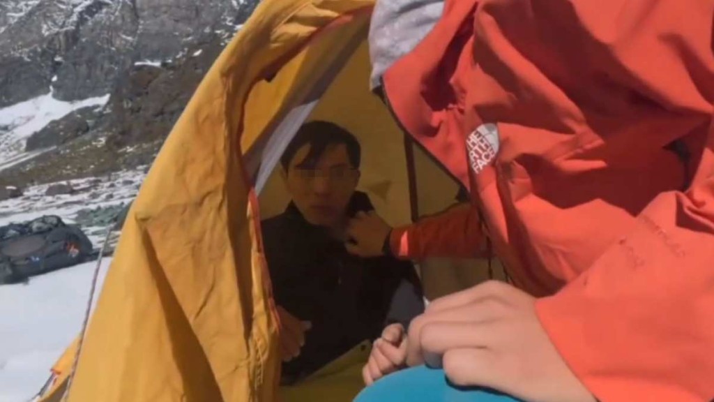 路過的登山者向高反初期，在原地候救的21歲男子了解情況。萬象觀察