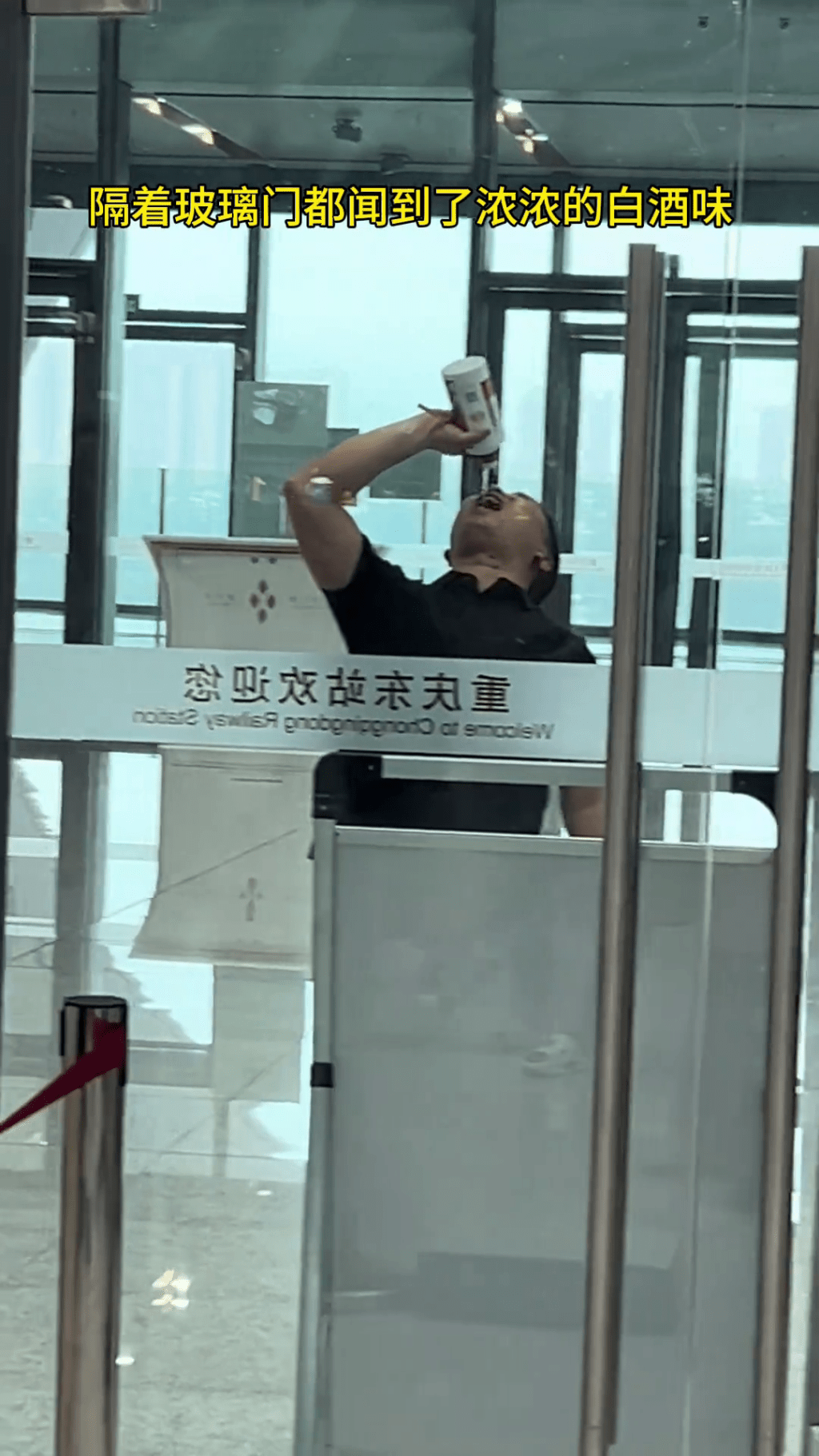 男乘客在安檢旁一口接一口的將整瓶茅台喝了。
