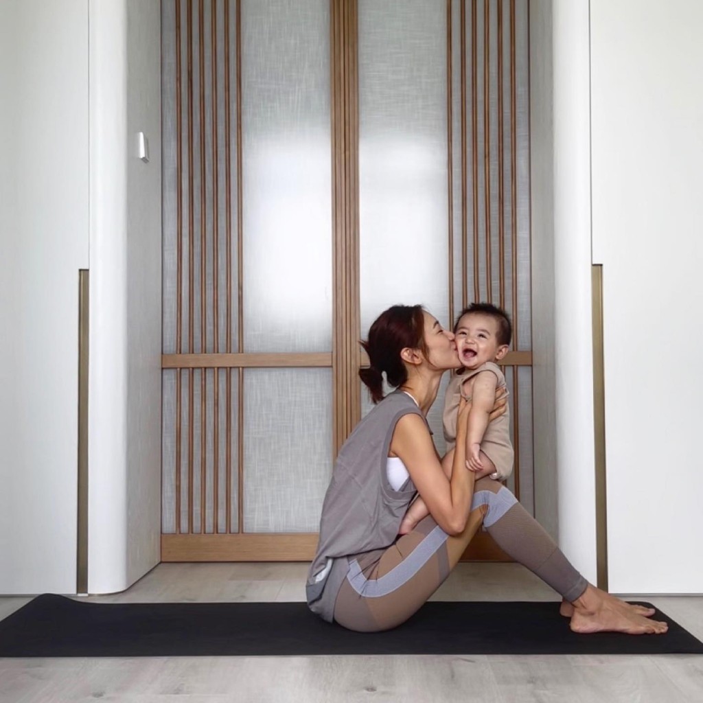 倪晨曦在家中抱住儿子做瑜伽。