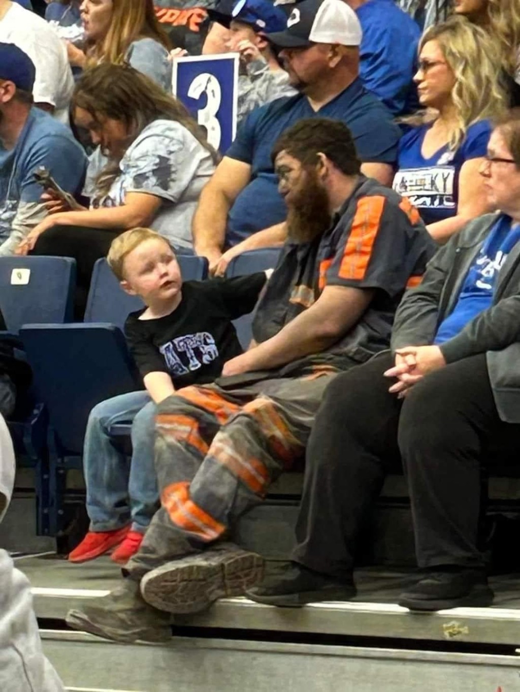 父親看起來滿身煤灰，與兒子觀賞籃球比賽。網圖