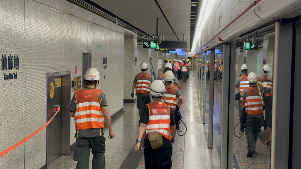 20多名身穿反光衣的港铁工程人员在场检查肇事列车车门甩脱位置。(刘汉权摄)