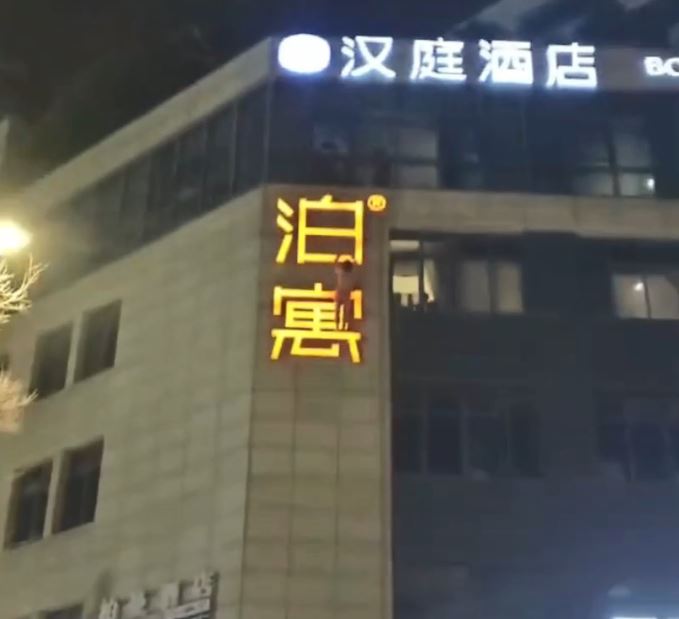 男子雙手抓住廣告牌。微博