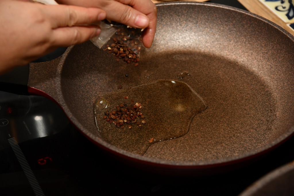 鑊內燒熱油兩湯匙，花椒以小火爆香，隔出花椒。Heat 2 tbsp oil in a pan. Saute the Sichuan pepper until fragrant, remove the Sichuan pepper.