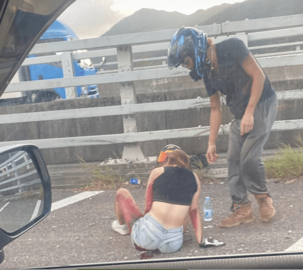車禍後,身穿黑色背心和淺色熱褲的梁女坐在地上,雙臂後側和左邊大腿滿佈鮮血,疑嚴重擦傷,而地上和牛仔褲近㬾部位置也染滿血跡。facebook群組「車cam L(香港群組)」 車禍後,身穿黑色背心和淺色熱褲的梁女坐在地上,雙臂後側和左邊大腿滿佈鮮血,疑嚴重擦傷,而地上和牛仔褲近㬾部位置也染滿血跡。facebook群組「車cam L(香港群組)」